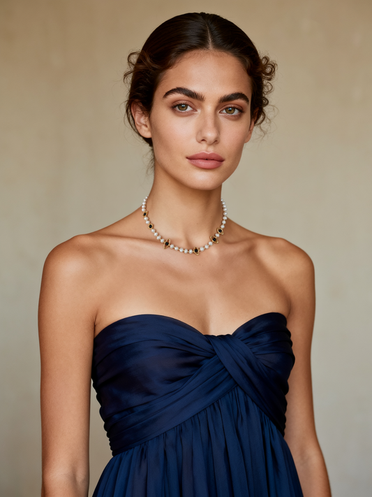 Model wearing the Ploutos Jewellery Celestial Eye Pearl Choker — a handcrafted necklace featuring freshwater pearls and black onyx gemstones framed in 18K vintage gold-plated recycled 925 sterling silver. From the Cosmic Energy Collection, this elegant design symbolizes intuition, protection, and inner balance, embodying quiet luxury and celestial charm.