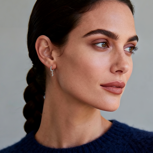 Model wearing Ploutos Jewellery Faithlight Cross Hoop Earrings in 925 sterling silver — minimalist hoop earrings with dangling cross charms from the Cosmic Energy Collection, radiating faith, balance, and quiet luxury.