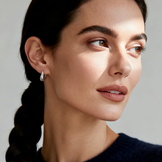 Model wearing Ploutos Jewellery Flora Arc Hoop Earrings in 925 sterling silver — sculptural petal-inspired hoops from the Abundance Collection, radiating modern elegance and organic sophistication under soft natural light.