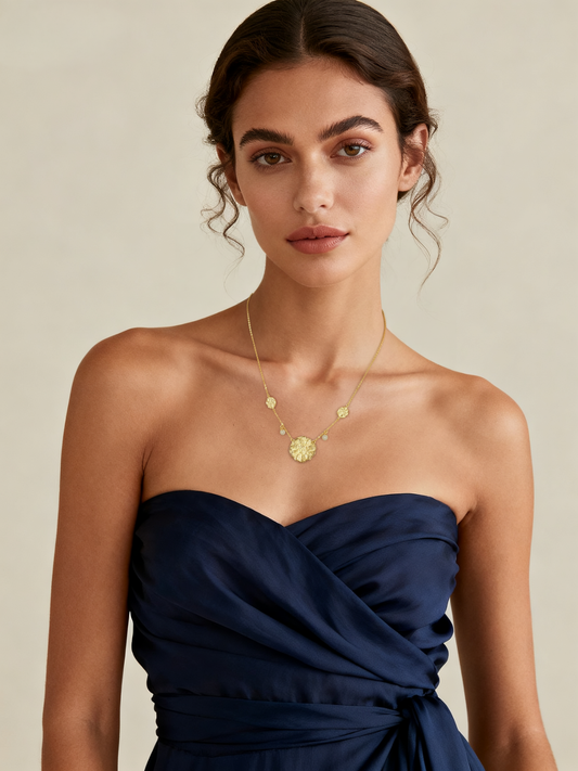 Model wearing Ploutos Jewellery Luna Bloom Gold Necklace — handcrafted 18K gold-plated 925 sterling silver necklace featuring a textured floral medallion and pearl accents. Elegant statement necklace from the Cosmic Energy Collection symbolizing growth, light, and divine femininity.