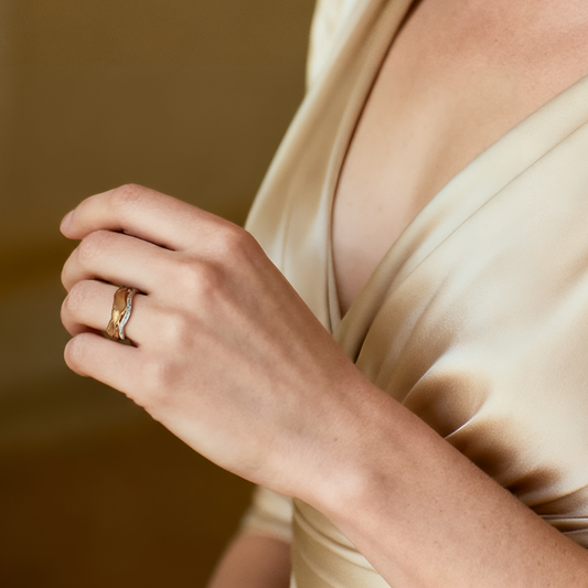 Model wearing Ploutos Jewellery Tidal Wave Ring — dual-tone 18K vintage gold-plated and silver open ring with cubic zirconia, handcrafted from recycled 925 sterling silver. Ocean-inspired wave design symbolizing balance and grace, part of the Wealth Collection’s elegant fine jewellery line.
