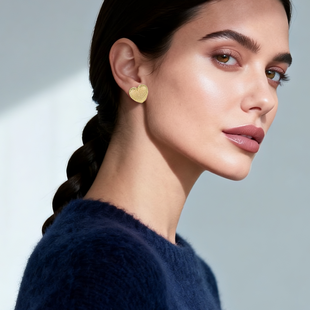 Model wearing 14k gold-plated textured heart stud earrings — elegant statement jewellery from the Wealth Collection by Ploutos Jewellery, embodying love, confidence, and quiet luxury style.