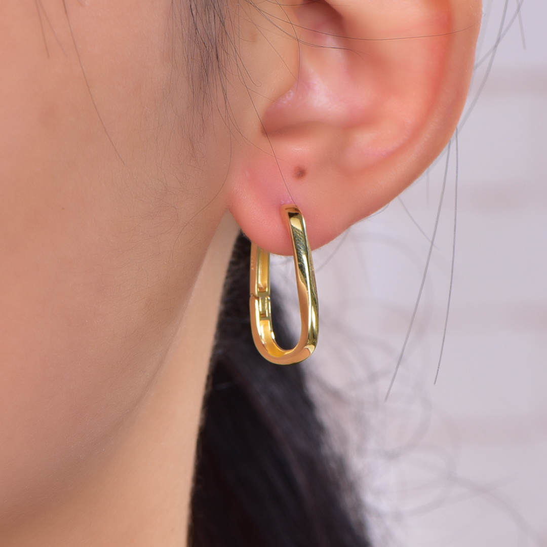 Model wearing 14K gold-plated rectangular hoop earrings from the Wealth Collection — sleek minimalist hoops with high-shine finish, elegant modern style for everyday luxury by Ploutos Jewellery.