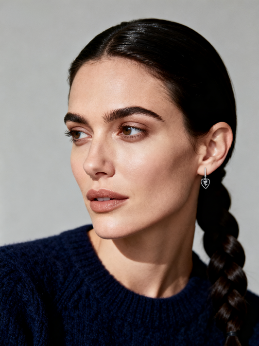 Model wearing Ploutos Jewellery Bloom in Noir Earrings — black onyx heart drop earrings with silver flower detail from the Abundance Collection, symbolising strength, femininity, and elegant minimalism.