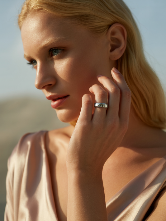“Model wearing Ploutos Jewellery Eterna Shine Silver Ring 6mm — handcrafted from 99.0% pure silver with a high-polish mirror finish. Styled with a soft champagne satin top under natural sunlight, representing quiet luxury and timeless elegance from the Abundance Collection.