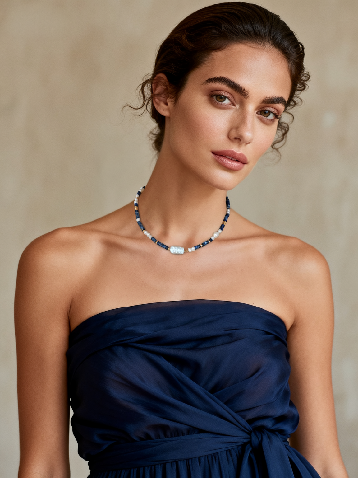 Model wearing Ploutos Jewellery Oceana Lapis Lazuli and Freshwater Pearl Choker — handcrafted with 18K vintage gold-plated recycled 925 sterling silver. This elegant piece from the Cosmic Energy Collection reflects ocean-inspired serenity, combining deep blue lapis stones and lustrous pearls for a timeless, graceful look.