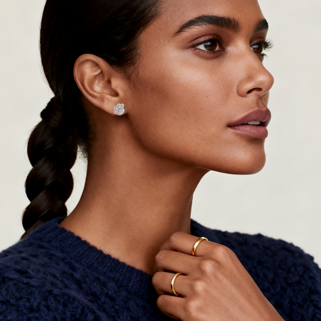 Model wearing Ploutos Jewellery Paw of Light Stud Earrings — 925 sterling silver with mother-of-pearl inlay from the Abundance Collection, symbolising love, warmth, and loyalty, styled with minimalist gold rings for an elegant everyday look.